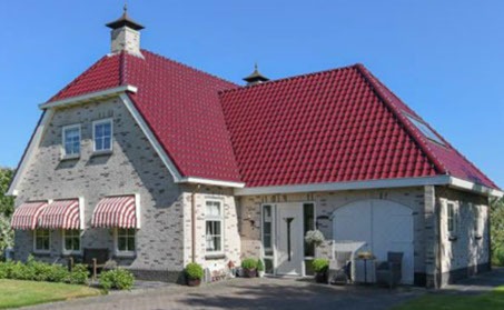 Boerderijwoning in grijze steen met rood dak