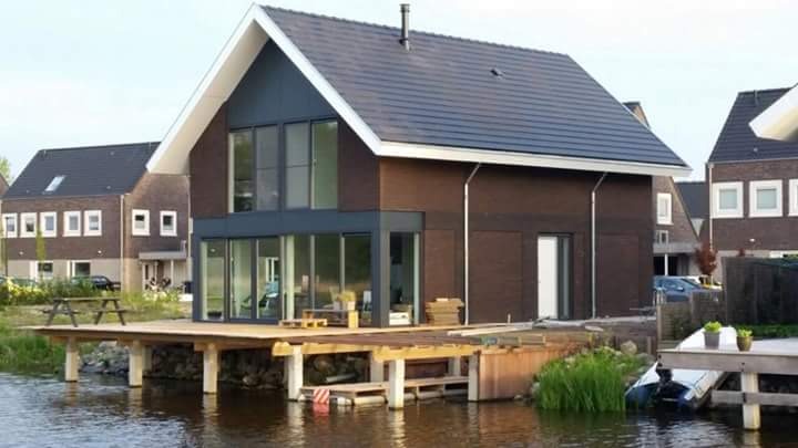 Bakstenen woning aan het water met steiger